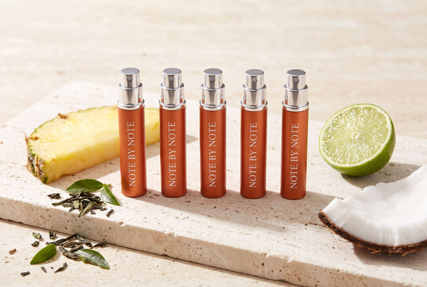 Five Note by Note travel sprays with pineapple, lime, coconut and green tea on travertine